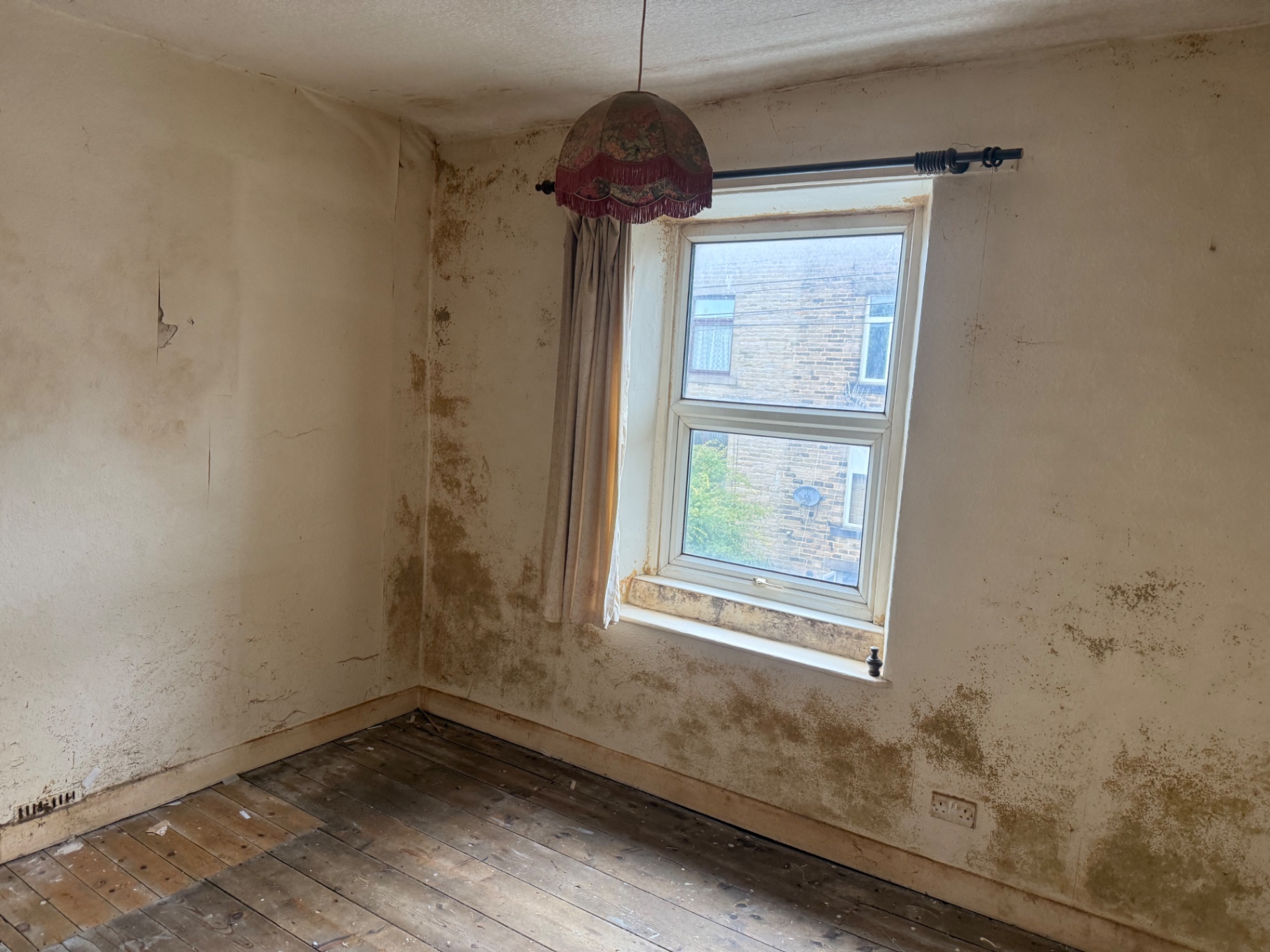 A room with worn floorboards after a full house clearance